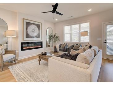 Bright living room featuring a modern fireplace, ceiling fan, stylish decor, and lots of natural light at 3350 Cranston Ln, Kennesaw, GA 30144