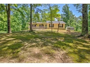 Inviting front porch with a rocking chair offering views of the surrounding yard and trees at 4950 Creel Rd, Chattahoochee Hills, GA 30213