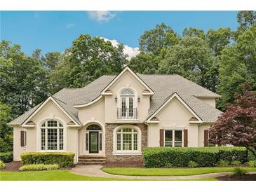 Charming two-story home with manicured landscaping, stone accents and a balcony overlooking the front yard at 5105 Deerlake Dr, Alpharetta, GA 30005