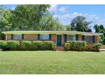 Charming brick home features a well-manicured lawn and lush landscaping at 606 Evergreen Dr, Woodstock, GA 30188