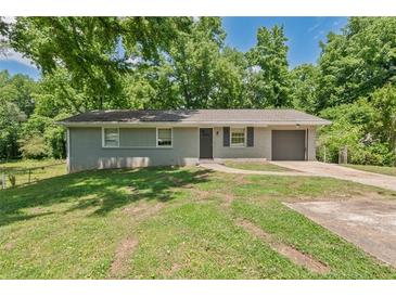 Charming single-story home with attached garage, large front yard, and mature trees at 2172 Se Wakita Se Dr, Marietta, GA 30060