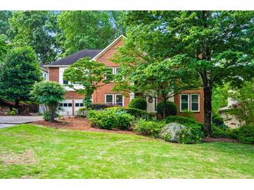 Charming two-story brick home with a well-manicured lawn and lush landscaping at 2610 Chadwick Rd, Marietta, GA 30066