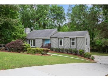Charming single-story home with a well-maintained lawn, neat landscaping, and light-blue front door at 3006 Alberta Dr, Marietta, GA 30062