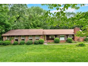 Charming ranch-style home with a brick facade, well-maintained lawn, and mature trees offering plenty of shade at 124 Chaseland Rd, Atlanta, GA 30328