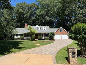 Charming single-story home featuring a brick driveway, attached garage, and well-maintained landscaping at 1477 Triple Creek Nw Ct, Kennesaw, GA 30144