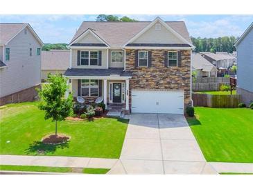 Charming two-story home featuring a stone facade, well-manicured lawn, and a welcoming front porch at 431 Hinton Farm Way, Dacula, GA 30019