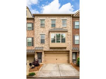 Charming brick townhome with a two-car garage and well-maintained landscaping at 275 Blue Pointe Ct, Suwanee, GA 30024