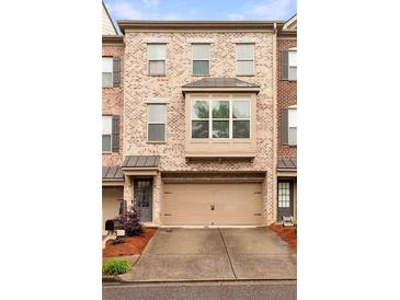 Charming brick townhouse with a two-car garage and a bay window feature at 275 Blue Pointe Ct, Suwanee, GA 30024