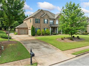 Stunning brick home featuring a manicured lawn, a two-car garage, and a long driveway for ample parking at 132 Shellbark Dr, Mcdonough, GA 30252