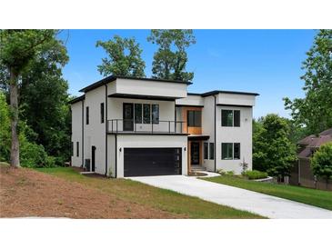 Modern two-story home with white exterior, black trim, balcony, and a driveway leading to an attached garage at 1610 Niskey Lake Rd, Atlanta, GA 30331