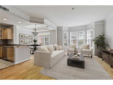 Bright living room features hardwood floors, bay window, open to kitchen and dining area, creating an inviting space at 850 Piedmont Ne Ave # 3304, Atlanta, GA 30308