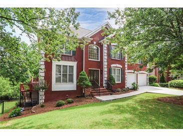 Beautiful two-story brick home with a well-manicured lawn and mature trees at 740 Creek Wind Ct, Duluth, GA 30097