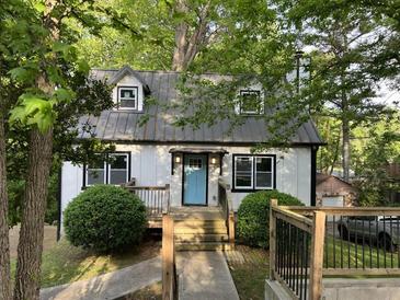 Charming home with a metal roof, light blue front door, and lush landscaping at 743 San Fernando Se Dr, Smyrna, GA 30080