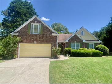 Charming brick home featuring a well-manicured lawn and a two-car garage in a quiet neighborhood at 4801 Devonhurst Way, Powder Springs, GA 30127