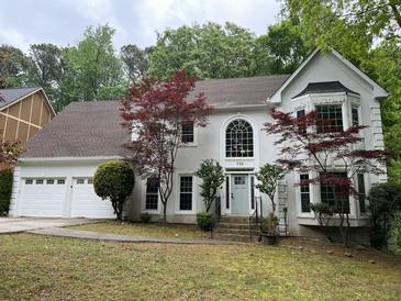Charming two-story home with a three-car garage, gray exterior, and beautifully landscaped front yard at 730 Redlion Run, Alpharetta, GA 30022