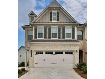 Charming two-story home featuring neutral siding, a front-entry two-car garage, and decorative window shutters at 6128 Lanier Harbor Lndg, Buford, GA 30518