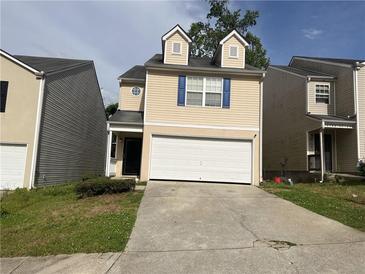Two-story home featuring a two-car garage, dormer windows, and neutral siding at 1263 Brookstone Rd, Atlanta, GA 30349