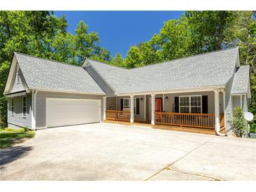 Charming single-story home featuring a spacious porch, two-car garage, and professionally landscaped front yard at 390 Rock Springs Pass, Dallas, GA 30157