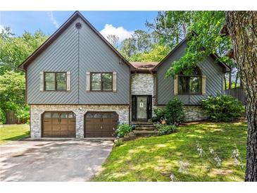 Charming exterior of gray home featuring brick accents, two-car garage, and well-maintained lawn at 143 Frances Dr, Dallas, GA 30157
