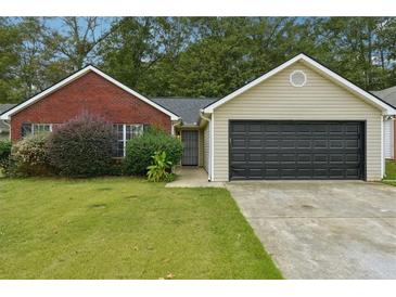 Charming single-story home with brick and siding, a well-manicured lawn, and an attached two-car garage at 11529 Vinea Ln, Hampton, GA 30228