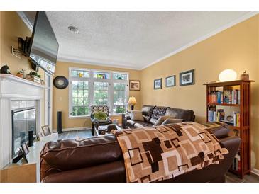 Inviting living room featuring a fireplace, large windows, and comfortable seating arrangement at 220 Renaissance Ne Pkwy # 1115, Atlanta, GA 30308