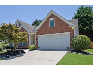 Charming brick home with a two-car garage, landscaped yard, and mature tree at 314 Santa Anita Ave, Woodstock, GA 30189