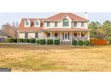 Charming two-story home with a welcoming front porch and well-manicured landscaping at 161 Honey Creek Rd, Mcdonough, GA 30252