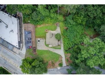 An aerial view showcases this single Gathering home nestled among mature trees with a long driveway at 2742 Alpine Rd, Atlanta, GA 30305