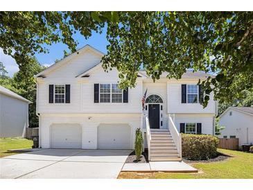 Charming two-story home featuring a two-car garage, black shutters, and a welcoming front porch with stairs at 6195 Queensdale Dr, Douglasville, GA 30135