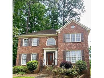 Charming two-story red brick home with landscaped front yard and decorative shutters at 3120 Saint Andrews Cir, Duluth, GA 30096