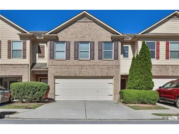 Charming brick townhome featuring a two-car garage and manicured landscaping in a well-maintained community at 328 Oaktown Ct, Lawrenceville, GA 30044