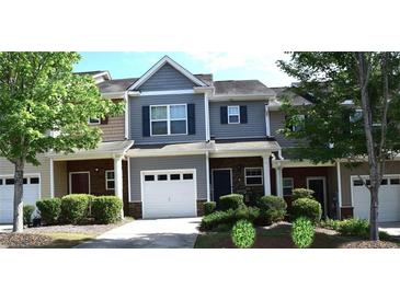 Charming townhome with gray siding, white garage door and driveway with manicured landscaping at 532 Oakside Pl, Acworth, GA 30102