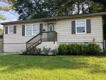 Charming single-story home featuring a well-maintained lawn, complemented by verdant greenery and a welcoming front entrance at 633 Tom Read Dr, Marietta, GA 30062