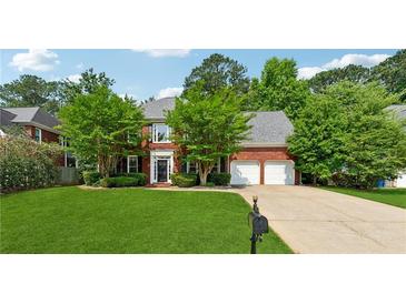 Charming brick home with a two-car garage, well-manicured lawn, and mature trees at 5013 Kendall Nw Sta, Acworth, GA 30102