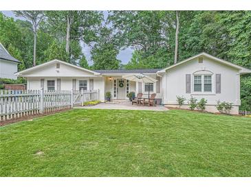 Charming single-story home with a well-manicured lawn, inviting patio, and beautiful landscaping at 1652 Tryon Ne Rd, Atlanta, GA 30319