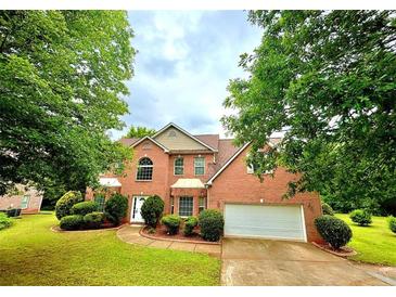 Charming two-story brick home featuring a manicured lawn, attached garage, and mature trees at 759 Hennepin Ter, Mcdonough, GA 30253