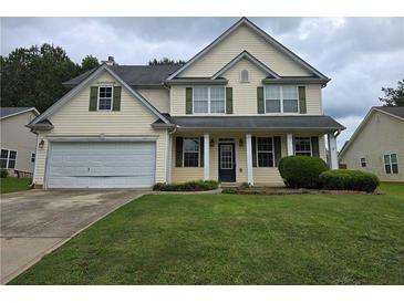 Charming two-story home with green lawn and attached two car garage at 5578 Swanson Rd, Ellenwood, GA 30294