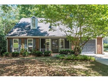 Charming brick home with a well-manicured lawn and attached garage at 402 Roswell Green Ln, Roswell, GA 30075