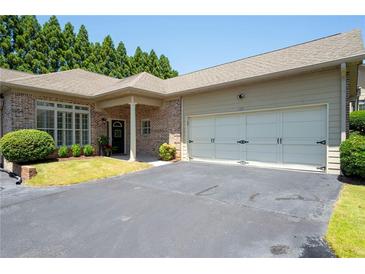 Charming home with brick accents, two-car garage and well-maintained landscaping at 530 Mount Park Dr, Powder Springs, GA 30127