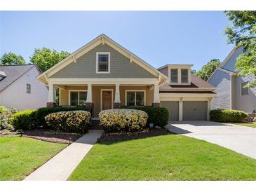 Charming home with inviting front porch, lush landscaping, and attached two-car garage at 6418 Crown Forest Ct, Mableton, GA 30126