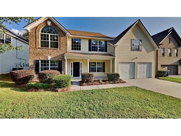 Charming two-story home featuring a well-maintained lawn, manicured shrubs, and a welcoming front entrance at 514 Jadetree Ln, Atlanta, GA 30349