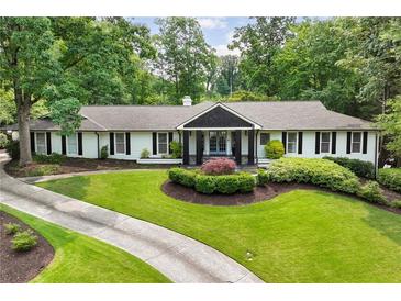 Charming ranch-style home with a beautifully landscaped front yard and circular driveway at 5860 Riverwood Dr, Sandy Springs, GA 30328