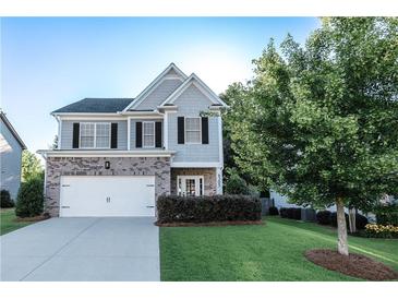 Charming two-story home with brick and gray siding, an attached garage, and a well-maintained lawn at 4305 Huron Dr, Cumming, GA 30028