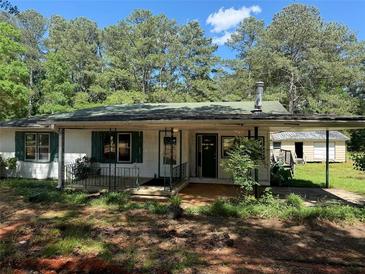 Charming single story home with covered porch, shutters, and mature trees at 1272 Cave Springs Rd, Douglasville, GA 30134