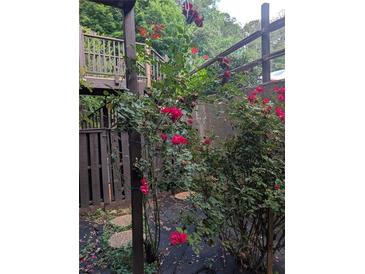 Beautiful red rose bushes climbing up the deck in this exterior yard view at 206 River Run Dr, Atlanta, GA 30350