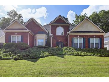 Charming two-story brick home featuring a manicured lawn and mature landscaping at 6772 Blantyre Boulevard Blvd, Stone Mountain, GA 30087
