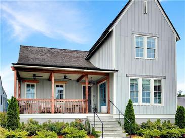 Charming gray two-story home with a welcoming front porch, landscaped yard, and eye-catching blue front door at 11260 Serenbe Ln, Chattahoochee Hills, GA 30268