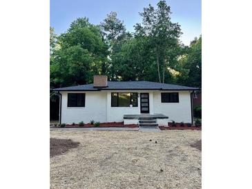 Charming single-story home with a brick chimney, fresh exterior paint, and a well-manicured front yard at 450 Collier Ridge Nw Dr, Atlanta, GA 30318