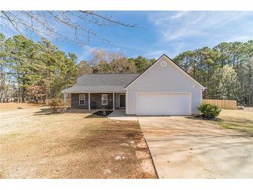 Charming single-story home with a two-car garage, stone accents, and inviting front porch on a spacious lot at 704 Stonecrest Ln, Loganville, GA 30052