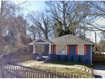 Charming blue bungalow featuring a covered porch and a fenced front yard at 836 Wood Nw St, Atlanta, GA 30318